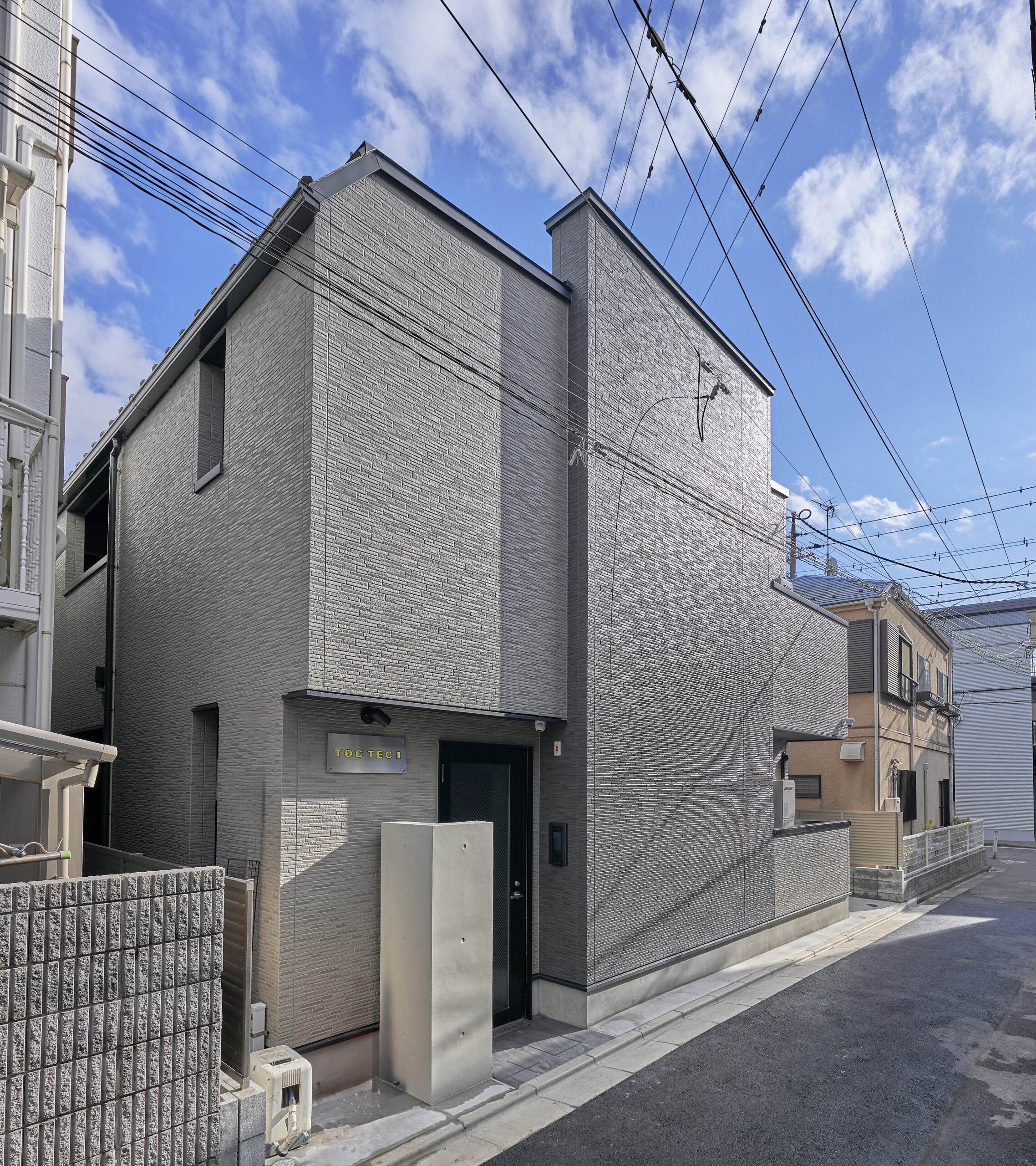 グレートーンでまとめた端正な佇まいの集合住宅